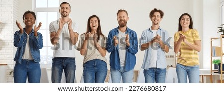 Team of happy diverse people clapping hands. Group of cheerful, joyful men and women in casual T shirts and jeans standing in office, smiling and applauding speaker for good presentation Royalty-Free Stock Photo #2276680817