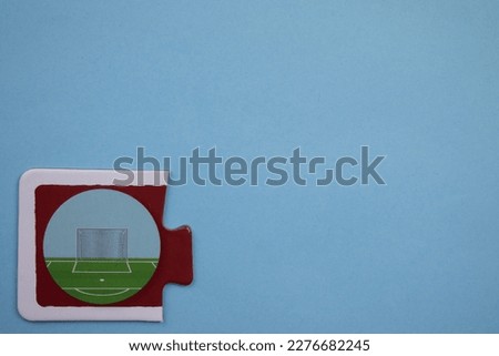 Soccer goal picture jigsaw, soccer goal picture jigsaw taken from above, placed on the left of a blue background.