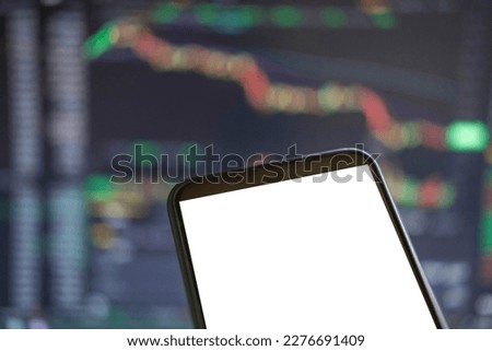 Black phone with blank mockup screen on rising stock graph. Closeup hand showing smartphone isolated white display. Online banking, Fund App use. Financial analyst on Invest Market. Bank collapse 2023