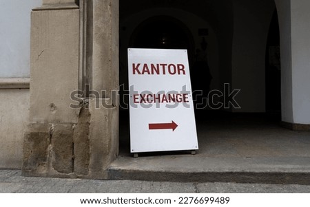 Word kantor in Polish language, means currency exchange. Sidewalk sign or sandwich board with arrow pointing to currency exchange shop kiosk or booth.