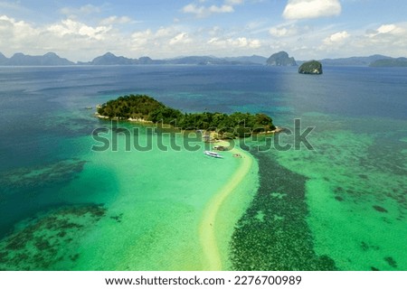 aerial horizontal panoramic photography of snake island in the archipelago el Nido, Philippines with cloudy sky and some tourist's boats