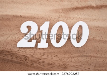 White number 2100 on a brown and light brown wooden background.