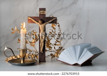 Crucifixion cross, candle and biblical book close up on table. Easter, Orthodox palm Sunday. Good Friday. symbol of Christianity, faith, Lent, prayer. Church religious holiday. Royalty-Free Stock Photo #2276703915