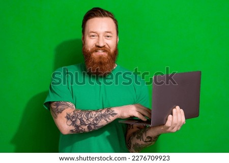 Photo of confident handsome man wear t-shirt working modern device isolated green color background