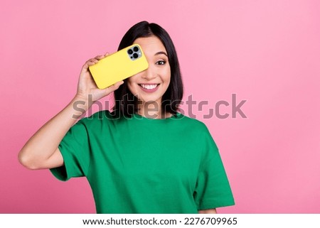 Portrait of positive cute woman with straight hairstyle wear oversize t-shirt smartphone cover eye isolated on pink color background Royalty-Free Stock Photo #2276709965