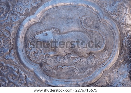 Carved image of a silver plate, a picture of a rat, symbolizing the year of the rat