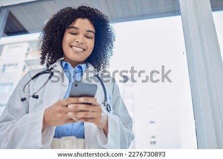 Phone, healthcare and woman doctor with mobile app, network or telehealth service for hospital management. Medical professional or biracial person typing on cellphone or smartphone in clinic below Royalty-Free Stock Photo #2276730893