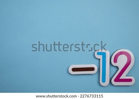 Minus 12 is the colorful inscription minus 12, taken from above, placed on the right of the blue background.