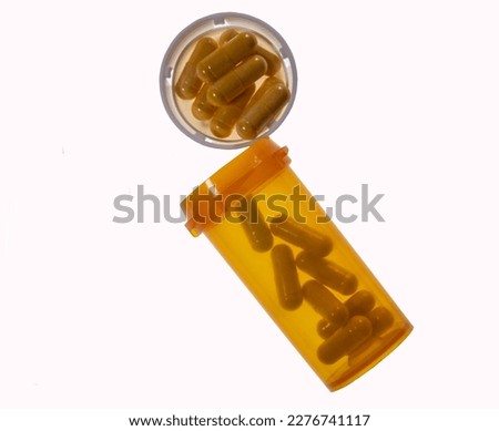 Isolation of pill bottle with pills in cap and bottle Royalty-Free Stock Photo #2276741117