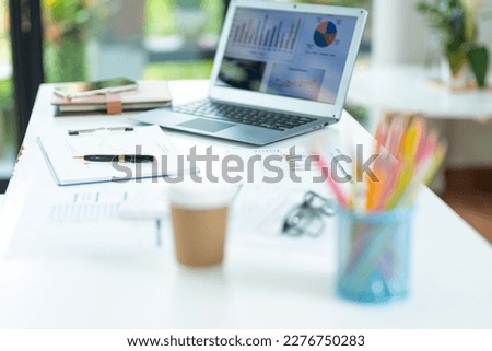 business desk with keyboard report chart pen and tablet on white table