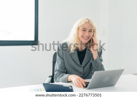 Focused on success and growth , Pretty young business woman working with computer while consulting some invoices and documents.