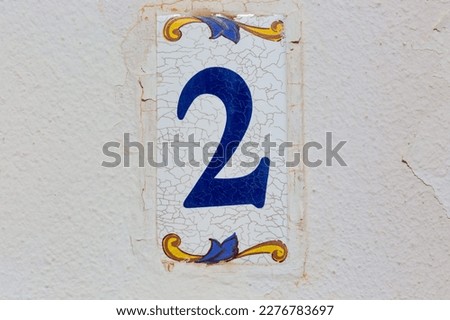 Old Weathered House Number 2, Tile on Wall Royalty-Free Stock Photo #2276783697