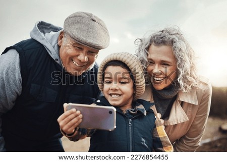 Selfie, happy and child with grandparents in nature for bonding, quality time and babysitting. Smile, interracial and boy taking a photo with a senior man and woman for a holiday or weekend memory