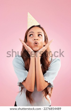 Birthday woman, studio and blowing kiss for celebration event, congratulations or celebrate happiness. Emoji gesture, party hat and relax female, person or young model looking on pink background
