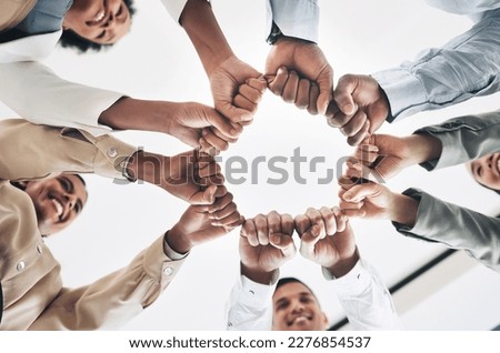 Team building, circle or happy business people fist bump for motivation in office meeting together. Diversity, low angle or employees with mission, strategy or group support for project goal