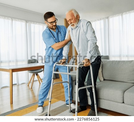Doctor or nurse caregiver with senior man using walker assistanece  at home or nursing home Royalty-Free Stock Photo #2276856125