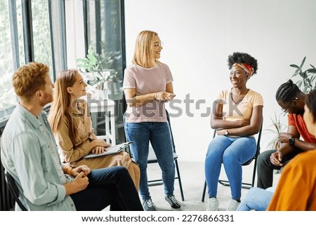 Group psychotherapy. Persons sitting in circle and talking. People meeting. Psychotherapy training, business lecture or conference. Man woman support group. Young businesspeople having a meeting  Royalty-Free Stock Photo #2276866331