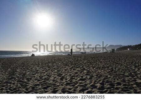 beautiful sandy stretches of Zuma Beach, Malibu in California in the last rays of the setting sun over the Pacific Ocean