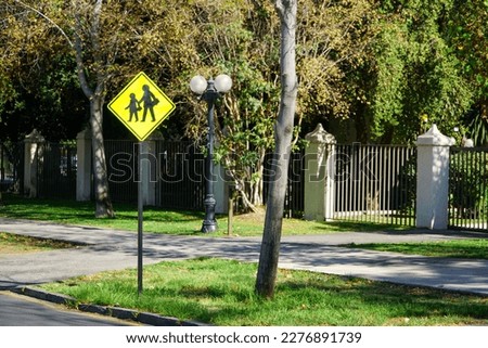 Image of a yellow traffic sign for kids and parents crossing the street in Santiago