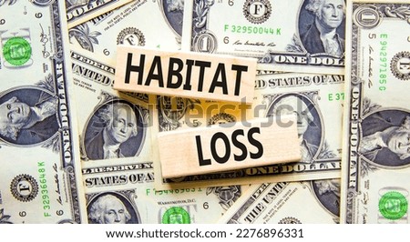 Habitat loss symbol. Concept words Habitat loss on wooden block. Beautiful background from dollar bills. Dollar bills. Business habitat loss concept. Copy space.