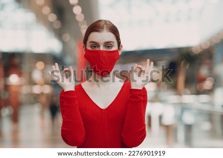 Portrait of young woman in protective medical face mask at shopping mall. Yoga, calm, zen and meditation a covid-19 pandemia concept.