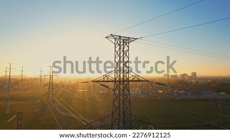 High voltage electricity pylon at golden hour background. International Earth Hour WWF event or power blackout concept. High electric hydro power demand due electric vehicle or EV use. 
