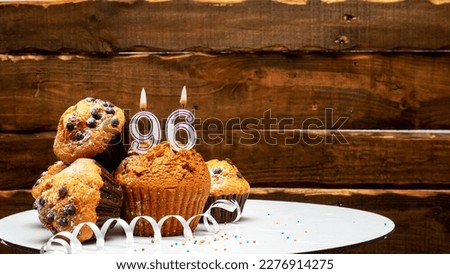 Pies with a number 96  of candles burning for the anniversary. Copy space background happy birthday on wooden background. Card or postcard festive rustic brown.