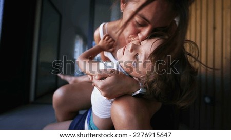 Mother kissing child son. Candid authentic real life mom kisses little boy in cheek embrace Royalty-Free Stock Photo #2276915647
