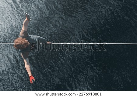 A man walks along a highline over water without insurance. Top view. Extreme activity and lifestyle Royalty-Free Stock Photo #2276918801