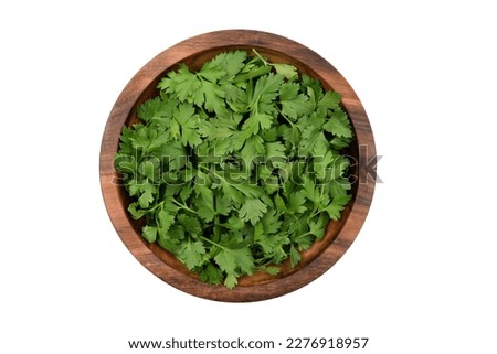 Chopped fresh parsley leaves in a wooden bowl, isolated on white background, top view Royalty-Free Stock Photo #2276918957