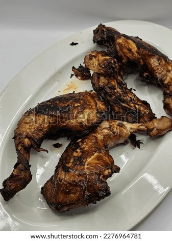 Picture of roasted chicken presented on oval plate.