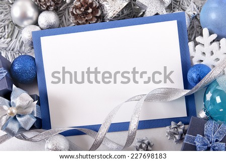 Blank Christmas card or invitation with blue envelope surrounded by decorations. Space for copy.