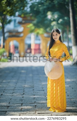 Ho Chi Minh city, Viet Nam: Vietnamese girl going to pagoda in ao dai Royalty-Free Stock Photo #2276983295