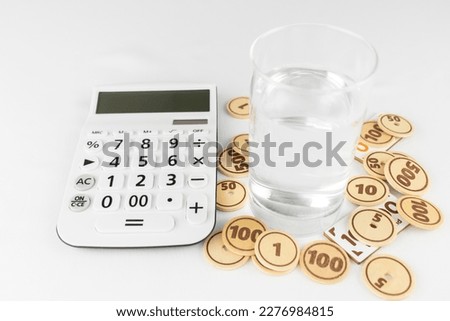 Calculator, water and toy money. image of water bill