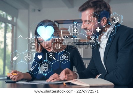 Businesspeople in formal wear taking notes signing contract at office workplace. Concept of important working moments, document sign, working process, concentration. Medical icons hologram