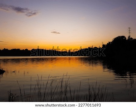 Beautiful sunset view on a lake. Silhouetted foreground.