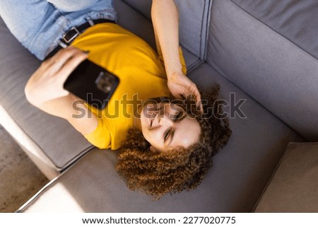 Portrait of a beautiful brunette taking a selfie with her smart phone at home