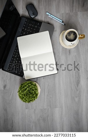 Working space at home, laptop, coffee mug and papers on wooden background