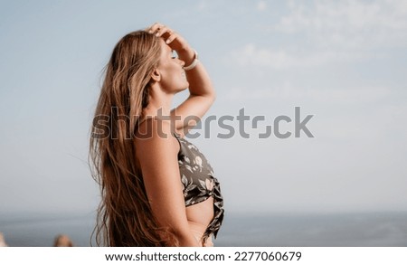 Woman travel sea. Happy tourist taking picture outdoors for memories. Woman traveler looks at the edge of the cliff on the sea bay of mountains, sharing travel adventure journey