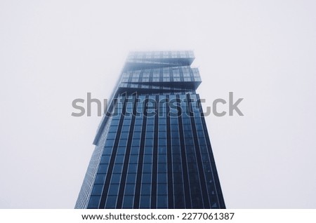 looking up at skyscrapers at a foggy overcast day 