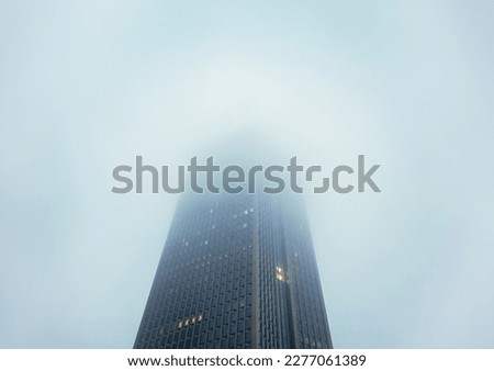 looking up at skyscrapers at a foggy overcast day 