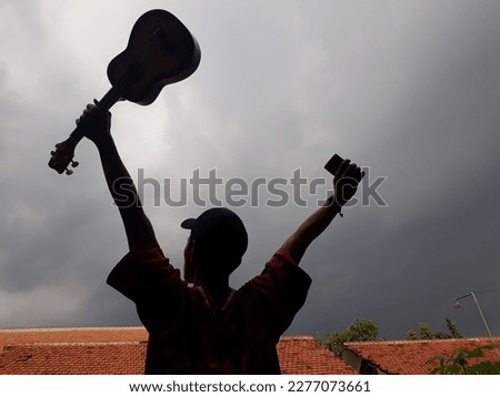 Shadow silhouette of man holding ukulele guitar