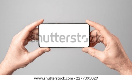 Mobile phone mock-up, horizontal smartphone screen mockup frame in male hands. Royalty-Free Stock Photo #2277095029