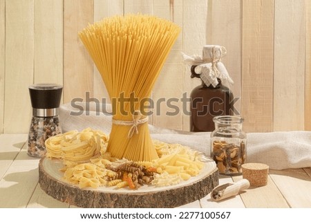 A bunch of dry spaghetti pasta in a stack horizontally. A pile of raw Italian pasta on a wooden background. copy space. Side view