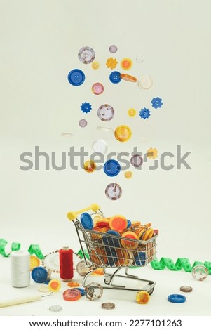 Multi-colored buttons of different shapes in a shopping cart. Lots of colorful buttons for clothes of different sizes. Side view
