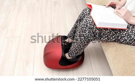 a girl does a massage on an electric foot massager. High quality photo