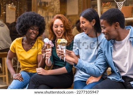 Multi-ethnic friends in an ice cream parlor sitting eating an ice cream, summer lifestyle having fun Royalty-Free Stock Photo #2277105947