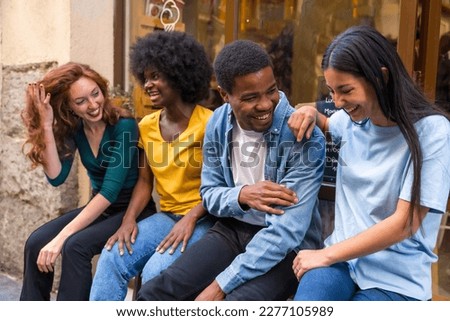 Multi-ethnic friends in a coffee shop sitting in the doorway of the shop window, having a lot of laughs Royalty-Free Stock Photo #2277105989