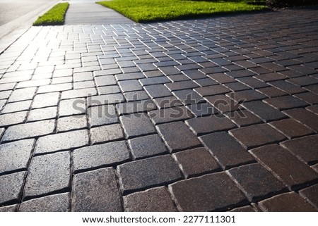 Close up showing driveway sealant to protect the bricks. Sealcoating background for new home construction. Royalty-Free Stock Photo #2277111301
