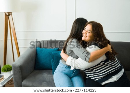 Loving happy women best friends smiling and hugging while sharing friendship love while sitting together on the sofa Royalty-Free Stock Photo #2277114223